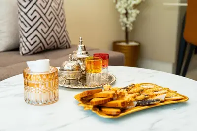 a white table with a plate of waffles and drinks at Suite Cosy Moderne Chic Calme Jardin and Habous in Casablanca