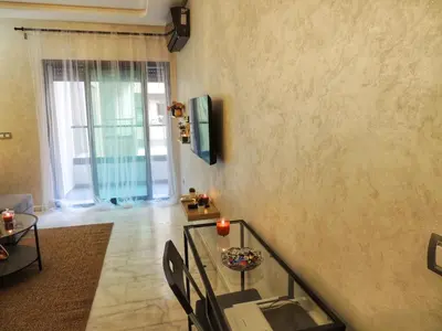 a living room with a glass table and a window at Appart de luxe, Confort et Emplacement, Corniche STAY MEMORIES in Mohammedia
