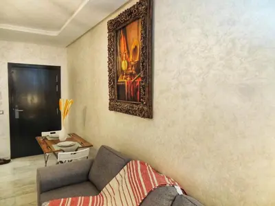 a living room with a couch and a picture on the wall at Appart de luxe, Confort et Emplacement, Corniche STAY MEMORIES in Mohammedia