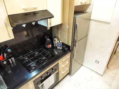 a small kitchen with a stove and a refrigerator at Appart de luxe, Confort et Emplacement, Corniche STAY MEMORIES in Mohammedia