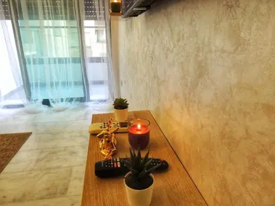 a living room with a table with a candle and plants at Appart de luxe, Confort et Emplacement, Corniche STAY MEMORIES in Mohammedia