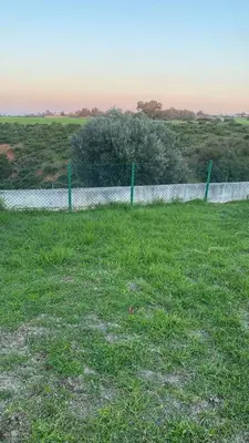a fence in a field with a body of water at Big Villa In Rabat in Rabat