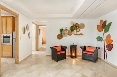 a living room with two chairs and a stove at Spacious, 2 BDR, Balcony, AC, Parking, Fiber Optic - Agdal in Rabat