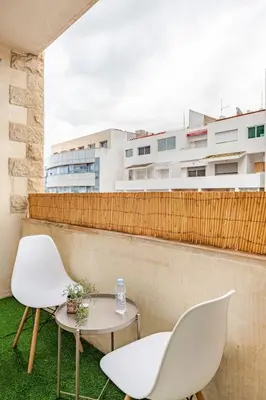 two white chairs and a table on a balcony at Spacious, 2 BDR, Balcony, AC, Parking, Fiber Optic - Agdal in Rabat