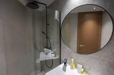 a bathroom with a shower and a sink and a mirror at B-living Luxury studio Maarif palmier in Casablanca