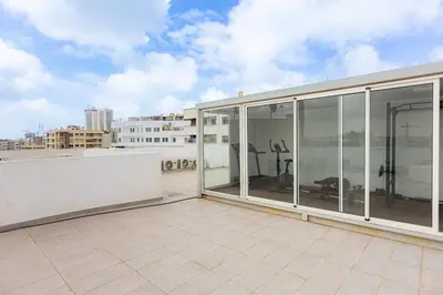 a large balcony with glass doors on a building at B-living Luxury studio Maarif palmier in Casablanca