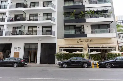 two cars parked in front of a building with umbrellas at B-living Luxury studio Maarif palmier in Casablanca