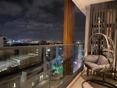 a balcony with a chair and a view of a city at VIVASTAY Casablanca - CFC High-Rise Luxury 2 Bedrooms Panoramic View in Casablanca
