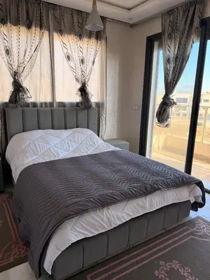 a bedroom with a large bed with a large window at Comfortable 2-bedroom apartment, beach within walking distance in Bouznika
