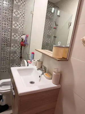 a bathroom with a sink and a mirror and a toilet at Comfortable 2-bedroom apartment, beach within walking distance in Bouznika