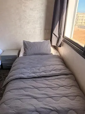 a bed in a small room with a window at Comfortable 2-bedroom apartment, beach within walking distance in Bouznika