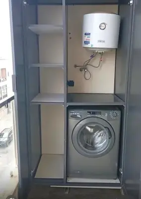 a washer and dryer in a gray cabinet at Comfortable 2-bedroom apartment, beach within walking distance in Bouznika