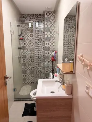 a bathroom with a shower and a sink and a toilet at Comfortable 2-bedroom apartment, beach within walking distance in Bouznika