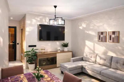 a living room with a couch and a tv at Spacious 3 Bedroom Apartment in Rabat Near Moulay El Hassan Stadium Malls and Embassies in Rabat