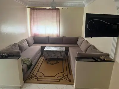 a living room with a couch and a table at Appart Tamaris DARB in Dar Bouazza