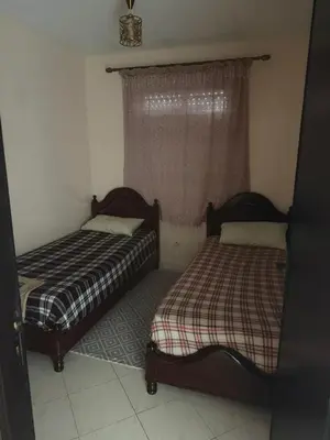 two beds sitting in a room with a window at Appart Tamaris DARB in Dar Bouazza