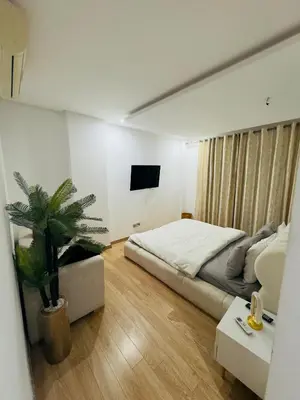 a bedroom with a bed and a potted plant at Granada in Rabat
