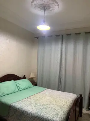 a bedroom with a bed with a light on the ceiling at Halimadriss in Rabat