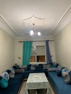 a living room with a blue couch and a table at Halimadriss in Rabat