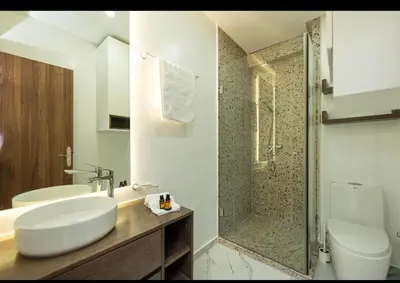 a white bathroom with a sink and a shower at Appartement Cosy avec Vue Piscine in Mansouria