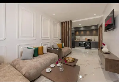 a living room with a couch and a table at Appartement Cosy avec Vue Piscine in Mansouria