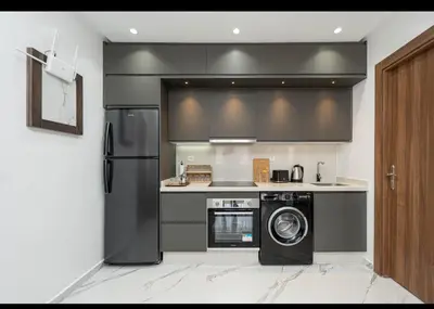 a kitchen with a refrigerator and a washing machine at Appartement Cosy avec Vue Piscine in Mansouria