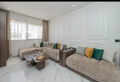 a living room with two couches and a table at Appartement Cosy avec Vue Piscine in Mansouria