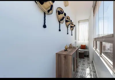 a living room with a wooden cabinet and a window at Appartement Cosy avec Vue Piscine in Mansouria