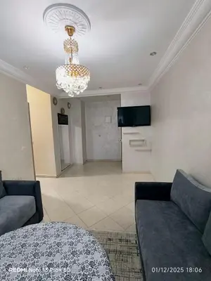 a living room with a couch and a chandelier at Appartement in Mohammedia