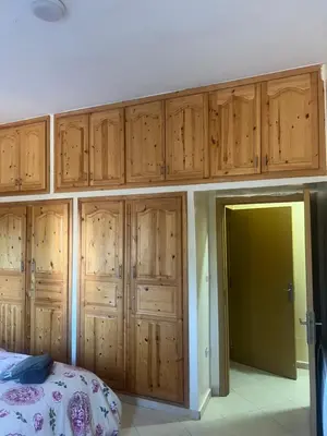 a bedroom with wooden cabinets above a bed at Appartement in Mohammedia