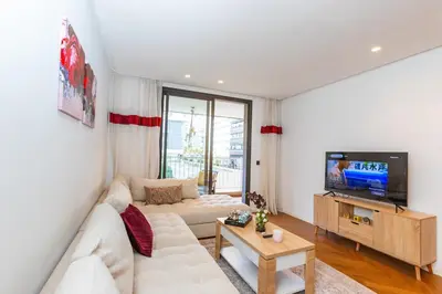 a living room with a white couch and a tv at Central Studio CFC I Gym I Pool in Casablanca