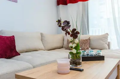 a living room with a couch and a table with a vase of flowers at Central Studio CFC I Gym I Pool in Casablanca