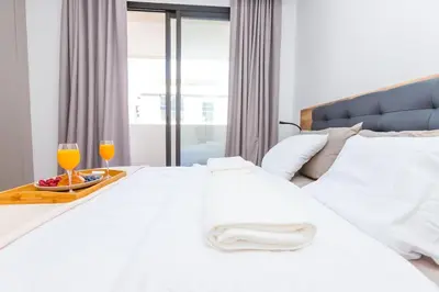 a bedroom with a white bed with two glasses of orange juice at Cosy Flat for Business Trip at CFC - Infinity Pool in Casablanca