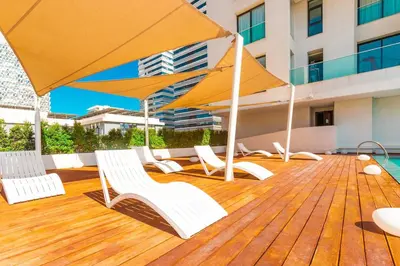 a deck with chairs and umbrellas on a building at Cosy Flat for Business Trip at CFC - Infinity Pool in Casablanca