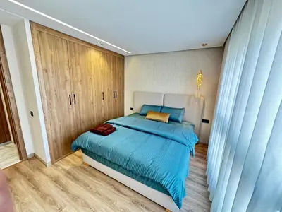 a bedroom with a large blue bed with blue sheets at France Ville 2 Appartement Meublé Premium avec Terrasse in Maarif