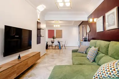 a living room with a green couch and a flat screen tv at Luxurious 2 BR, AC, Parking, Elevator - Mall Arribat Center, Agdal in Rabat