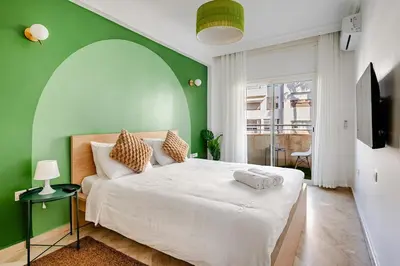 a bedroom with a white bed with a green wall at Luxurious 2 BR, AC, Parking, Elevator - Mall Arribat Center, Agdal in Rabat