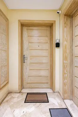 a wooden door in a room with mats on the floor at Luxurious 2 BR, AC, Parking, Elevator - Mall Arribat Center, Agdal in Rabat