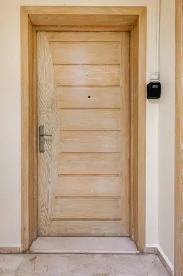a wooden door in a white room with at Luxurious 2 BR, AC, Parking, Elevator - Mall Arribat Center, Agdal in Rabat