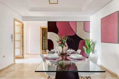 a dining room with a glass table and chairs at Luxurious 2 BR, AC, Parking, Elevator - Mall Arribat Center, Agdal in Rabat