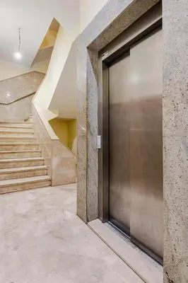 a metal door in a hallway with stairs at Luxurious 2 BR, AC, Parking, Elevator - Mall Arribat Center, Agdal in Rabat