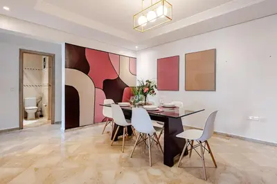 a dining room with a table and white chairs at Luxurious 2 BR, AC, Parking, Elevator - Mall Arribat Center, Agdal in Rabat