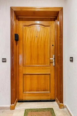 a wooden door in a room with a rug at Modern, 1 BDR, AC, Parking, Elevator, Fiber Optic - Agdal in Rabat
