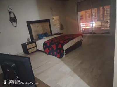 a bedroom with a bed and a dresser and a tv at Apparttement BOUCHRA in Casablanca
