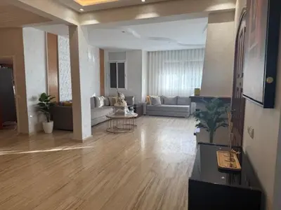 a large living room with a couch and a table at VILLA BOUSKOURA Casablanca in Casablanca
