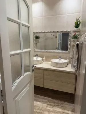 a bathroom with two sinks and a mirror at VILLA BOUSKOURA Casablanca in Casablanca