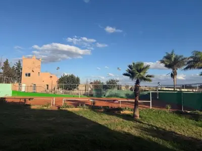 a park with a tennis court with a palm tree at VILLA BOUSKOURA Casablanca in Casablanca