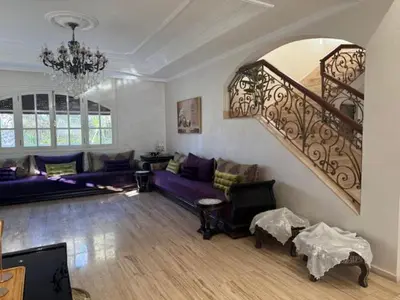 a living room with purple couches and a staircase at VILLA BOUSKOURA Casablanca in Casablanca