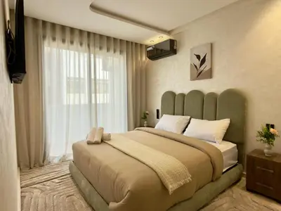 a bedroom with a large bed with a large window at Appartement de Luxe près du CFC et de l Hôpital Cheikh Khalifa in Casablanca