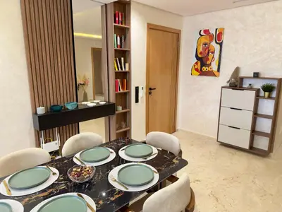 a dining room with a table with plates and chairs at Appartement de Luxe près du CFC et de l Hôpital Cheikh Khalifa in Casablanca